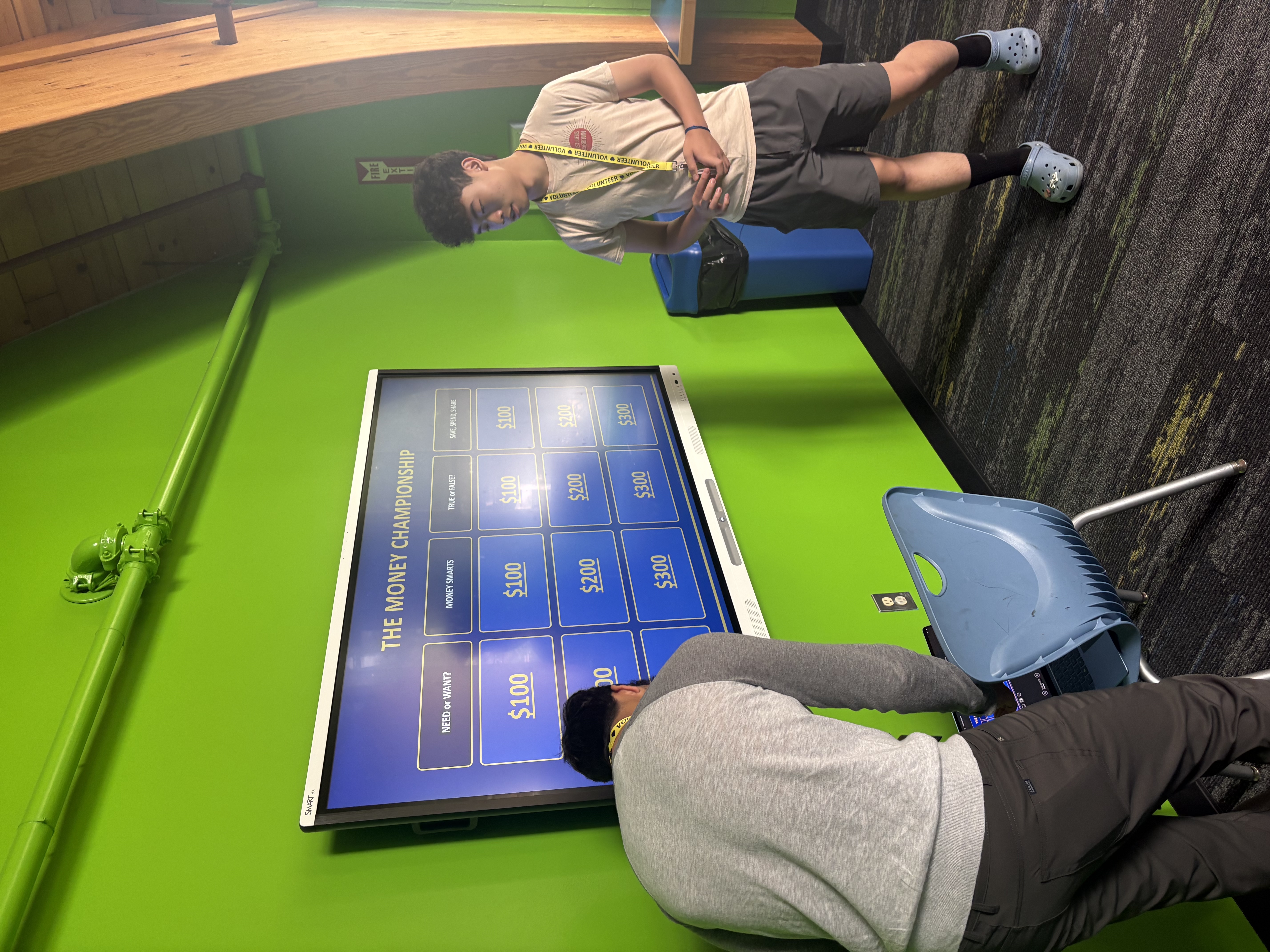 Students playing the budgeting board game around an interactive table.