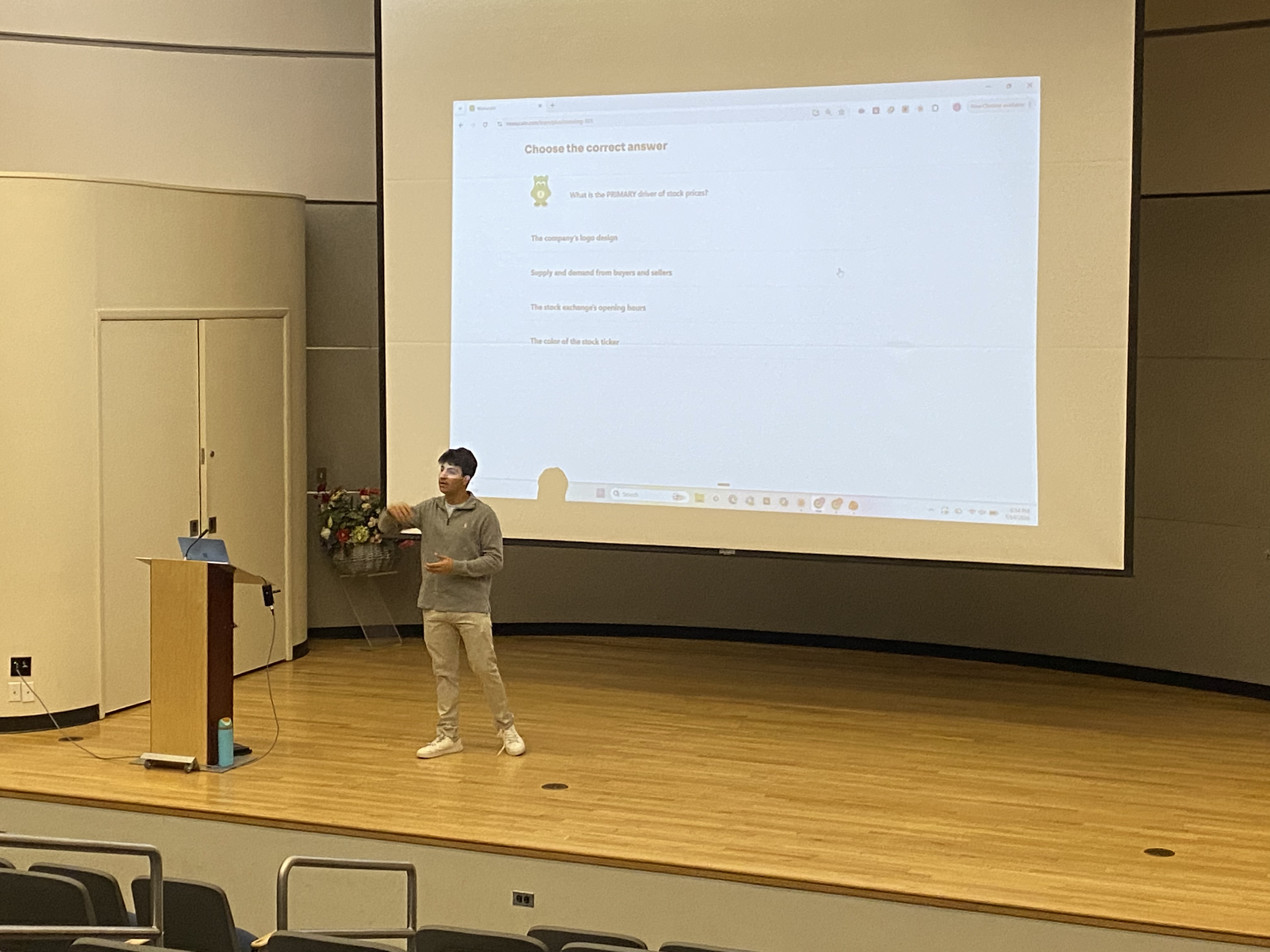 Presenting the compound interest curve on a full auditorium screen.
